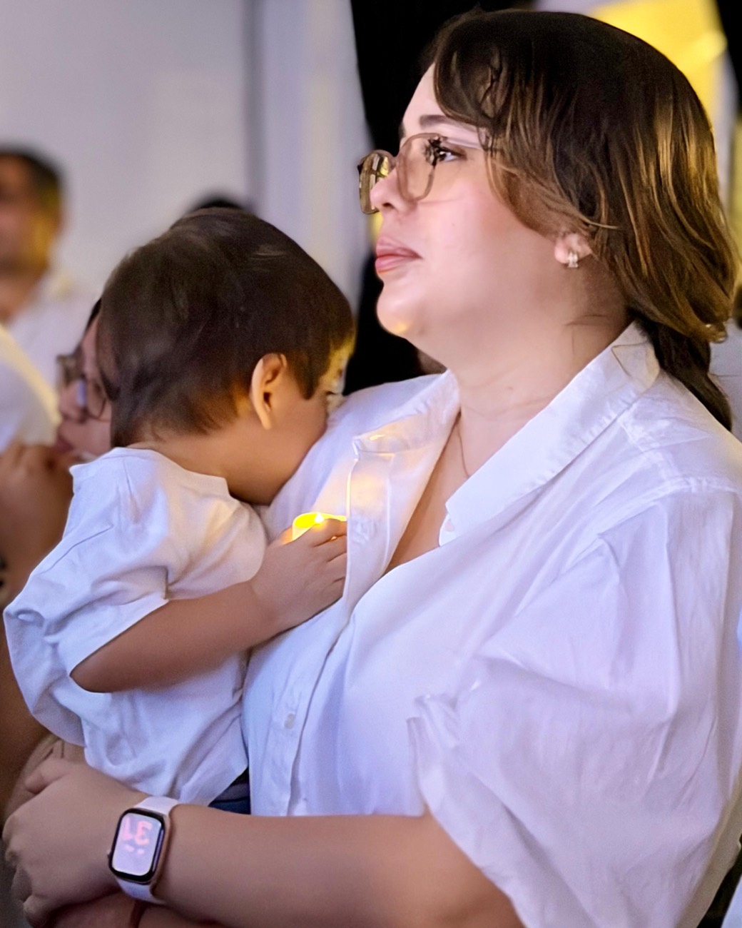 Madre cargando a su hijo durante la adoración