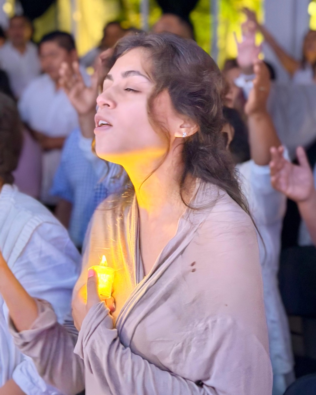 Mujer en adoración sosteniendo una vela