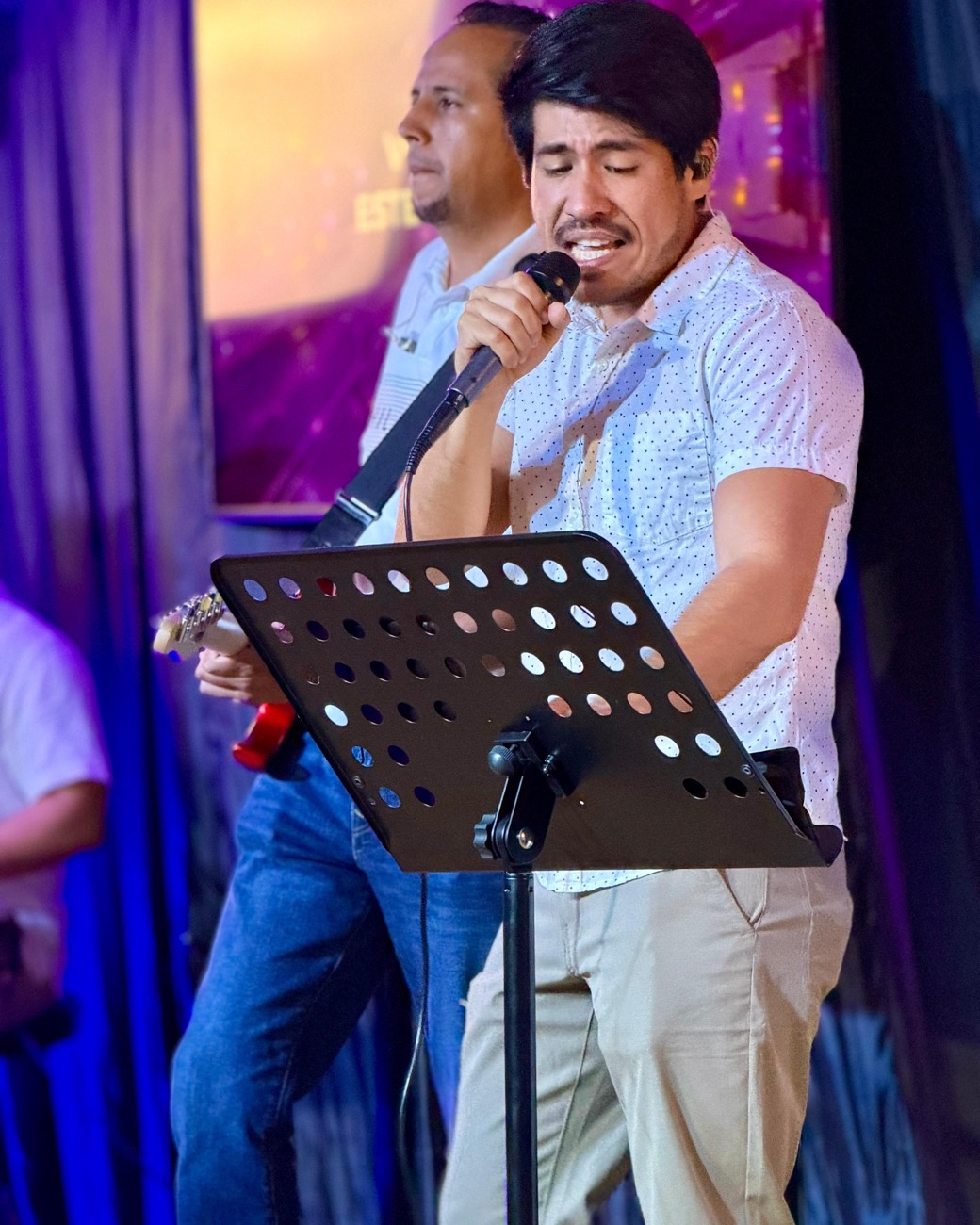 Hombre cantando al micrófono en el culto